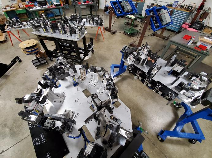 Industrial workshop with multiple jigs and fixtures, possibly for manufacturing, on stands.
