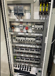 Electrical control panel with switches, breakers, and wiring.