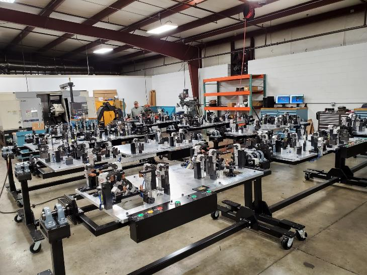 Workshop with multiple black workstations. Each station holds various mechanical parts.