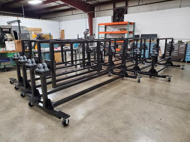 Black metal rolling racks in a workshop.