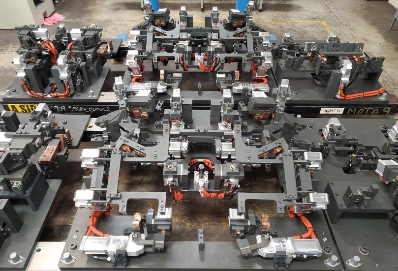 Complex industrial machine with various arms and components, arranged in a grid pattern.