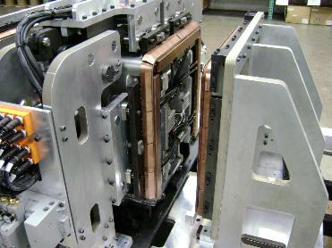 Close-up of industrial machinery, featuring copper components and metal framework, likely for manufacturing.