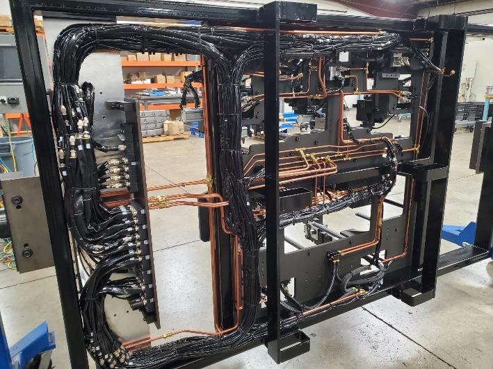 Black metal frame with electrical wiring and copper tubing.