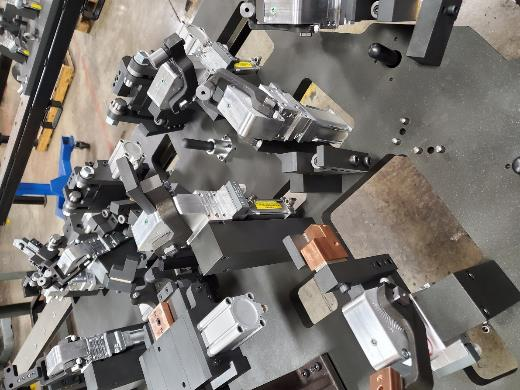 Metal machine parts scattered on a workbench in a workshop setting.