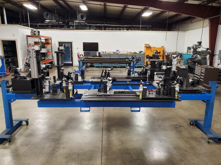 Blue metal industrial assembly jig on a shop floor.