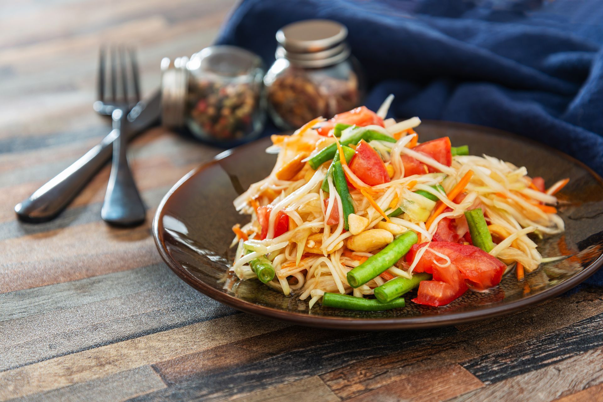 A close up of a plate of food on a wooden table.
