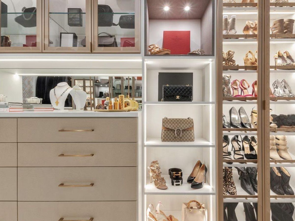 Built-in closet with drawers, shelves, handbags, shoes, and glass-front display cabinets