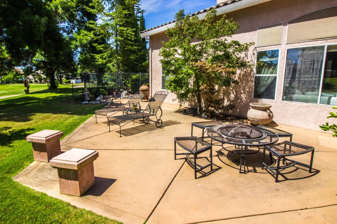 Backyard concrete patio with outdoor furniture and landscaping in Leesburg