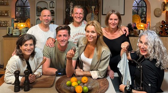 De presentatoren van Eigen Huis & Tuin leunen lachend op het aanrecht van de set van het programma.