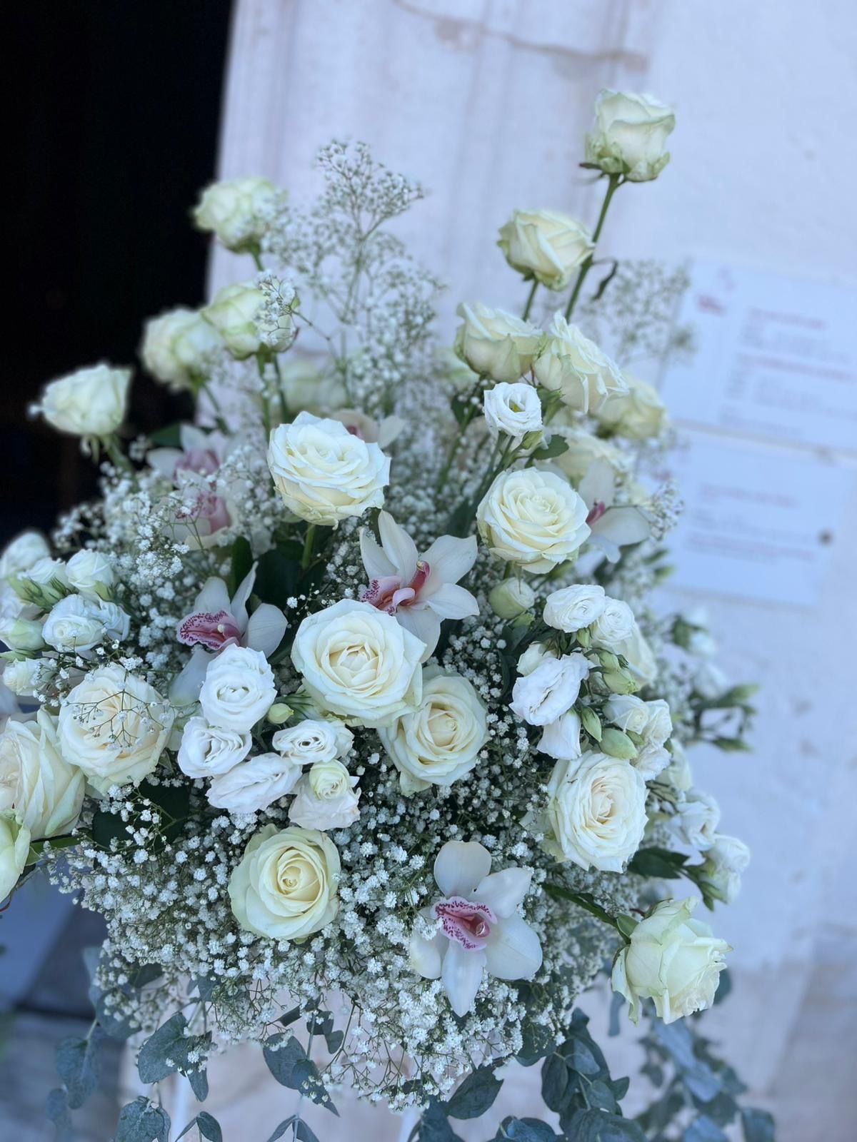 Composizione floreale con rose bianche e gypsophila.
