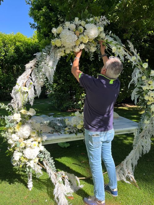 Primo piano di una composizione floreale con rose bianche e rosa, ortensie e gypsophila.