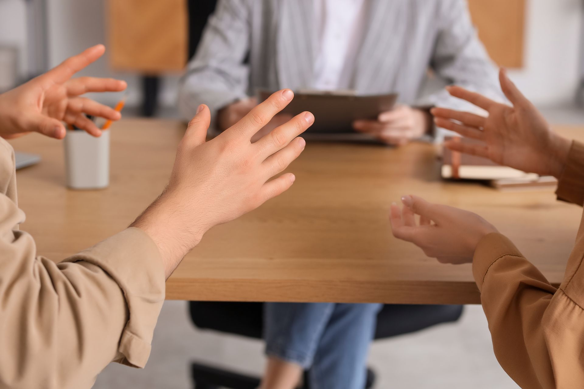 Hands gesturing around a conference table during a group discussion
