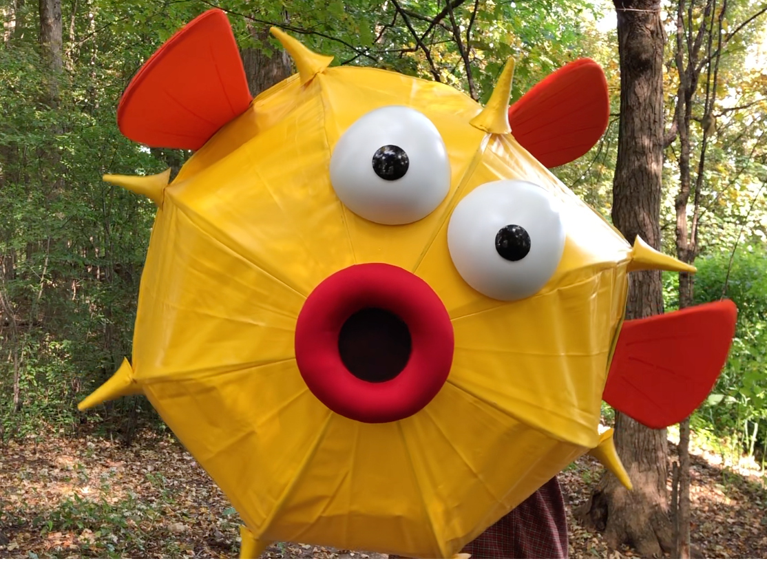 A person is wearing a yellow puffer fish costume