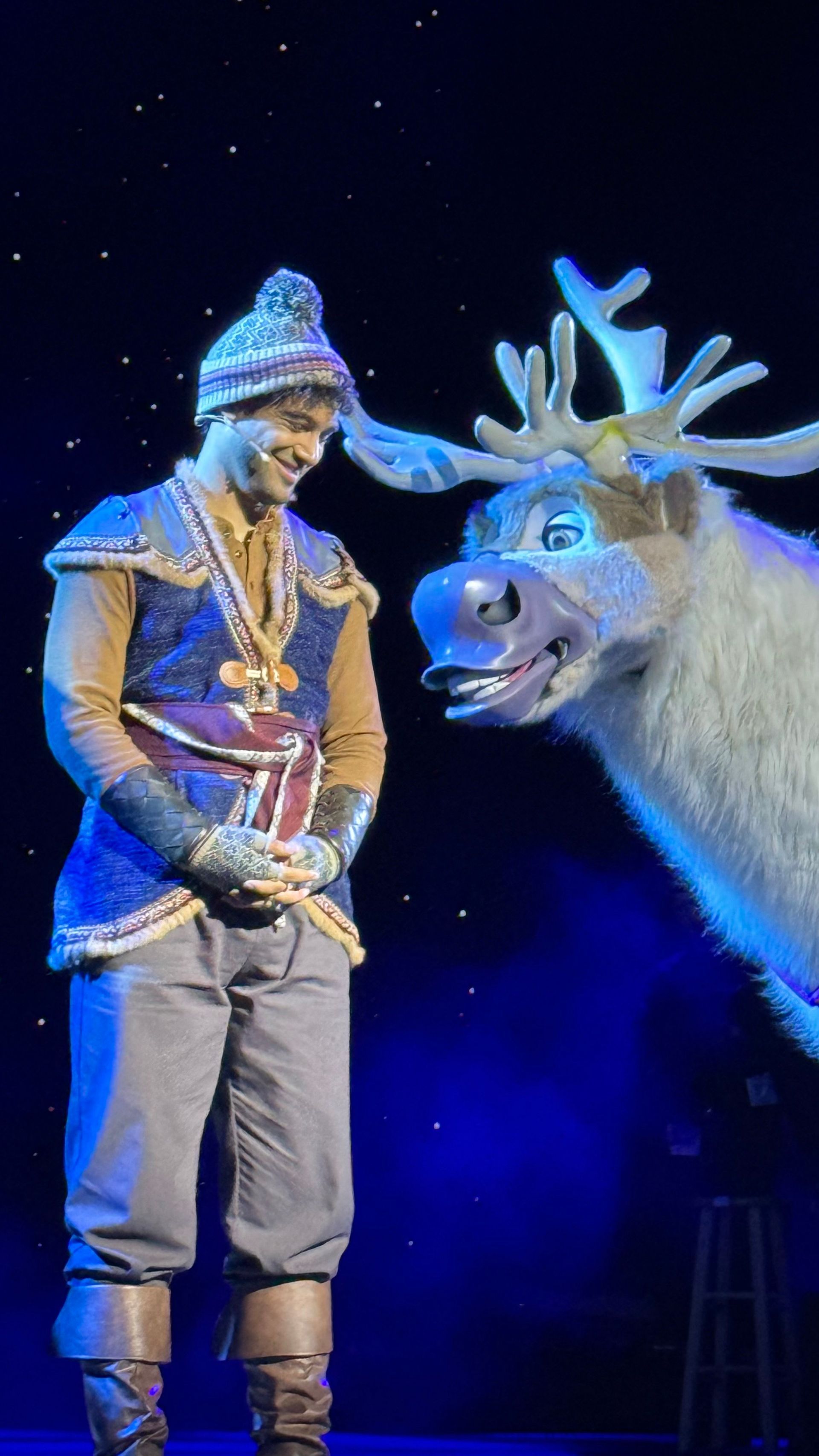A man is standing next to a reindeer on a stage.