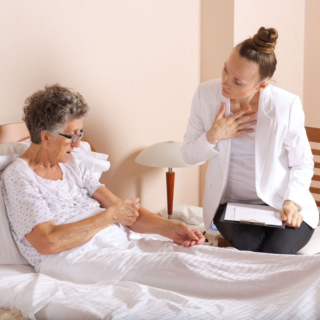 Hospice Social Worker speaking with a patient sitting up in bed