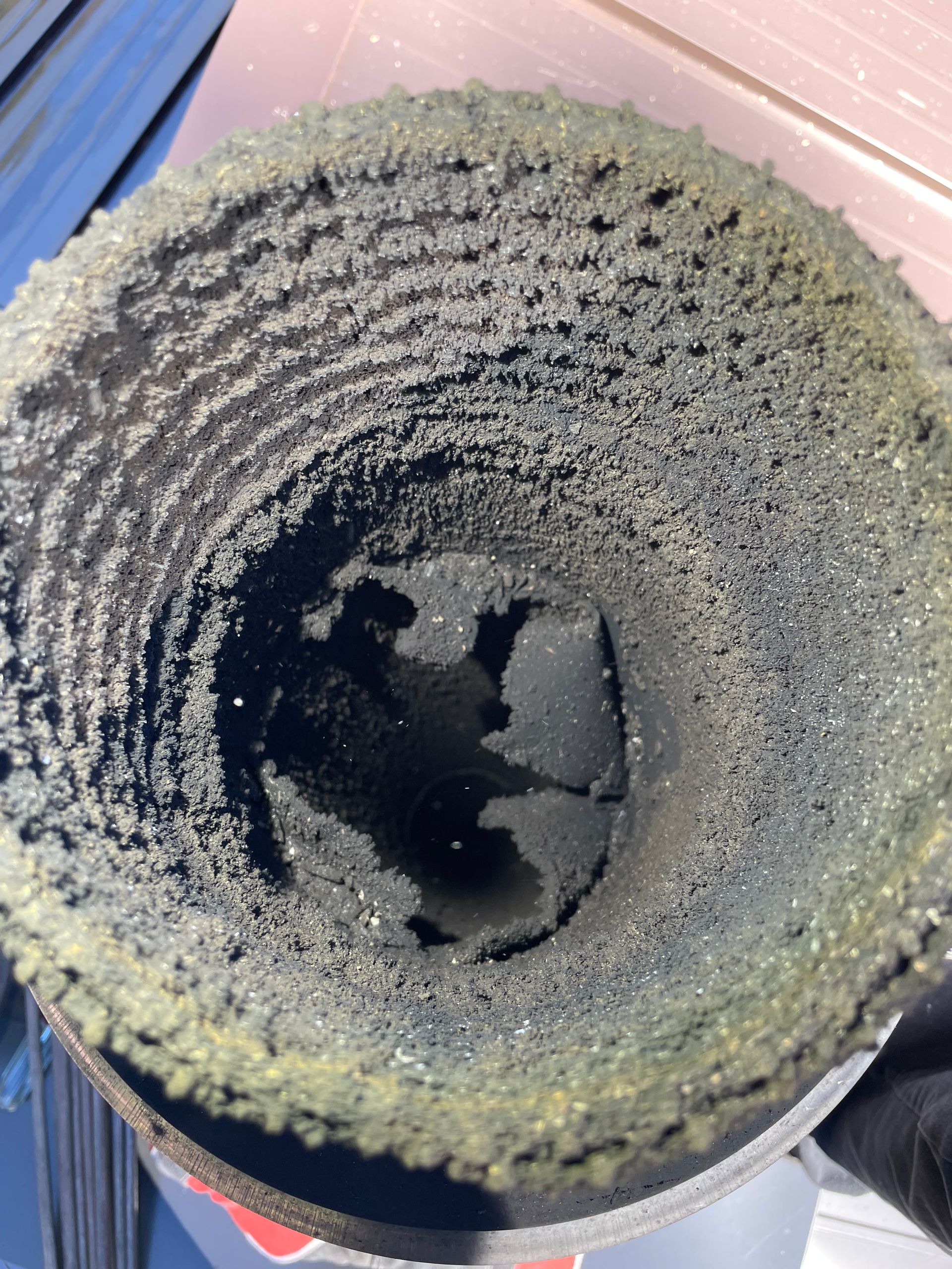 Looking down a chimney, coated in thick, light-colored creosote and soot.