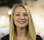 a woman with long blonde hair is smiling for the camera .