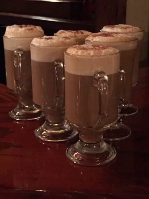 a row of coffee cups on a wooden table