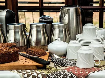 a table topped with plates , cups , utensils , and a piece of cake .