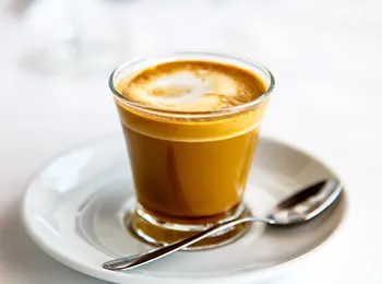 a cup of coffee with a spoon on a saucer