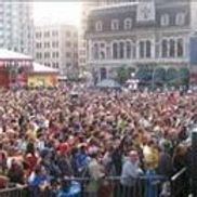 Foule importante rassemblée en milieu urbain, probablement pour un concert ou un événement. Bâtiments visibles en arrière-plan.