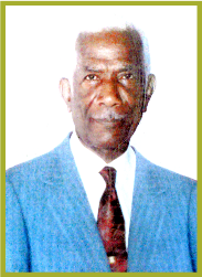 Portrait of an elderly man in a light blue suit and red tie against a white background
