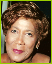 Close-up portrait of a woman with short brown hair and pink lipstick against a dark background