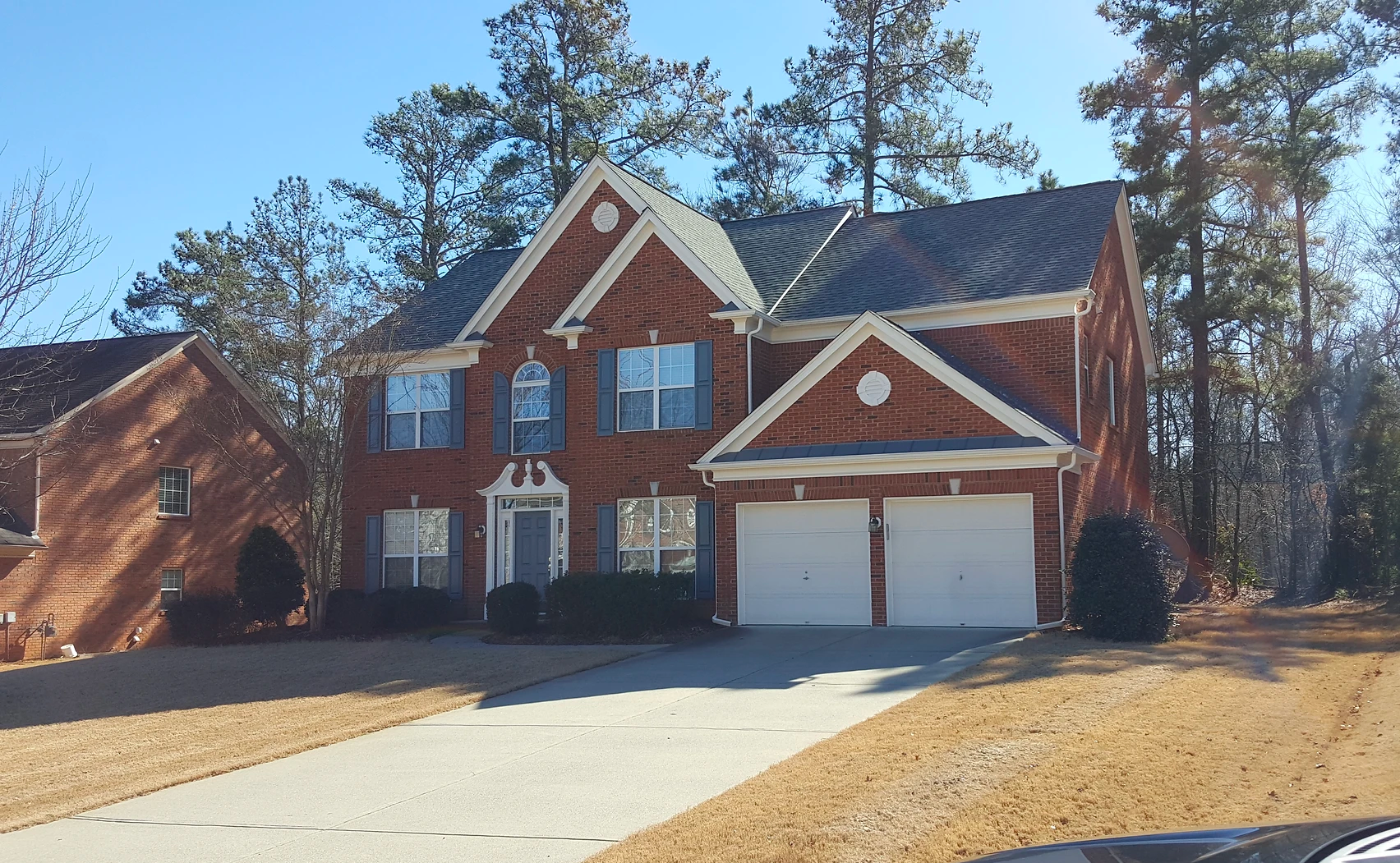 A large brick house with two white garage doors