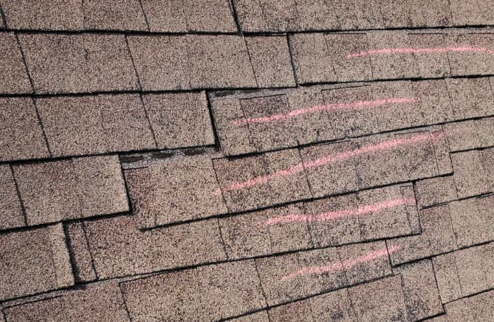 A close up of a roof with a lot of shingles missing.