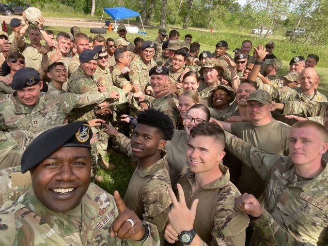 A group of soldiers are posing for a picture in a field.