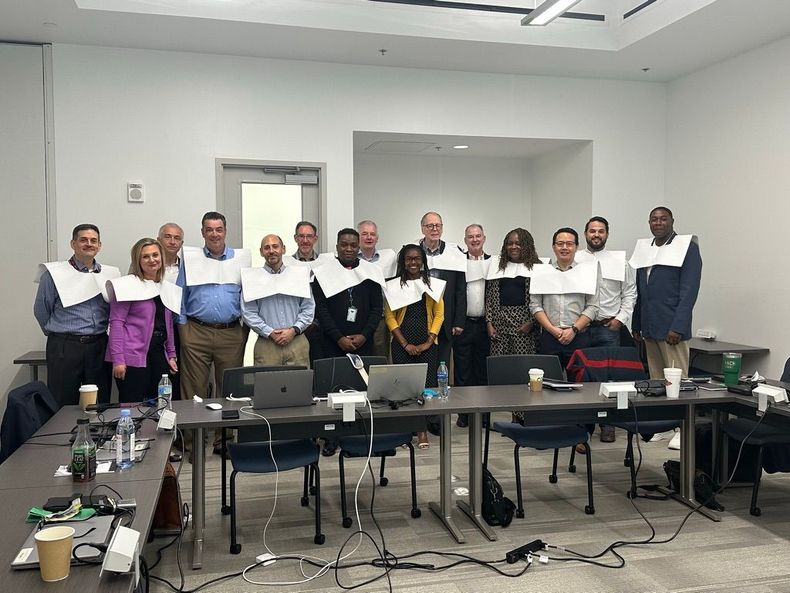 A group of people are posing for a picture in a conference room.