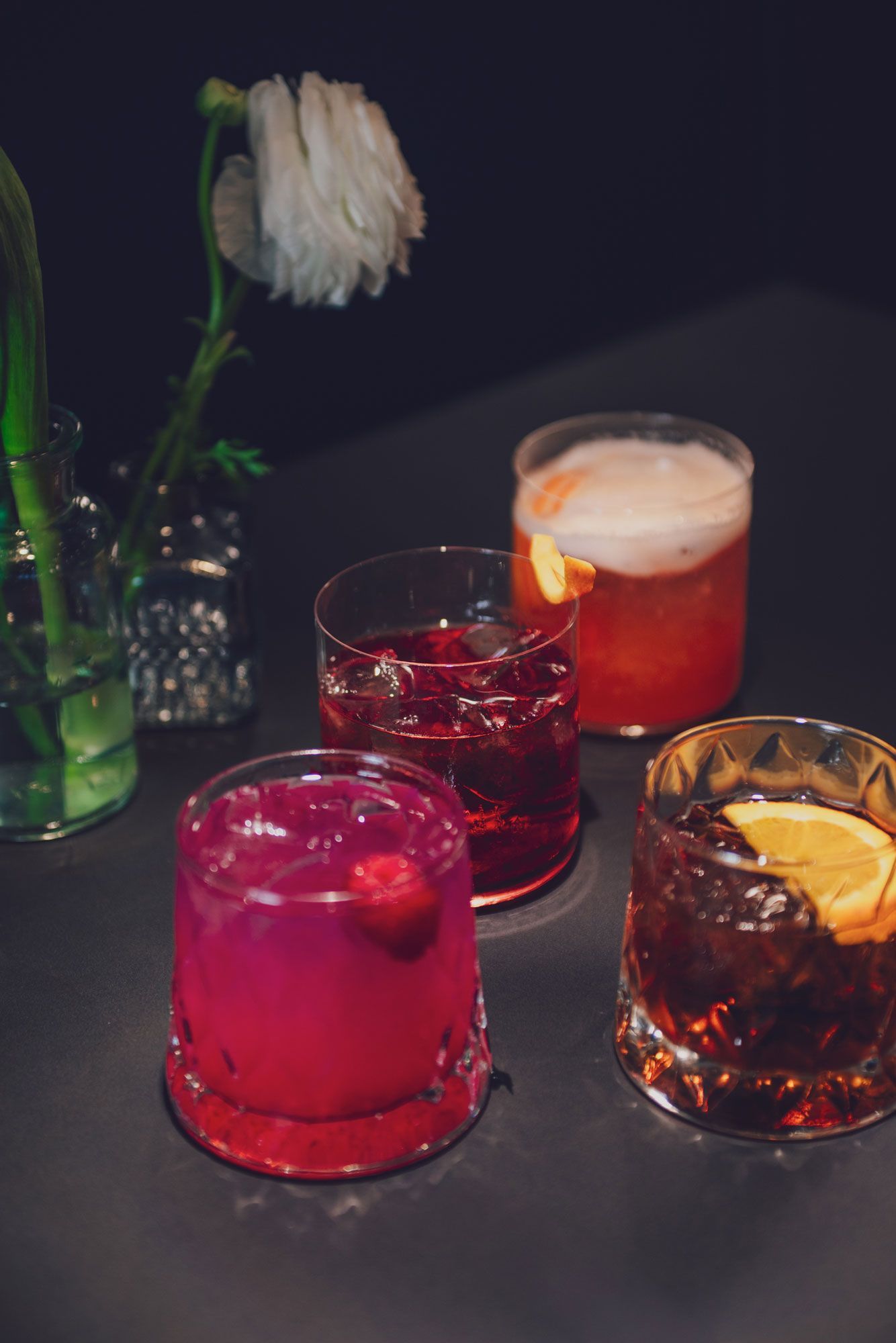 diversi cocktail colorati con guarnizioni di agrumi