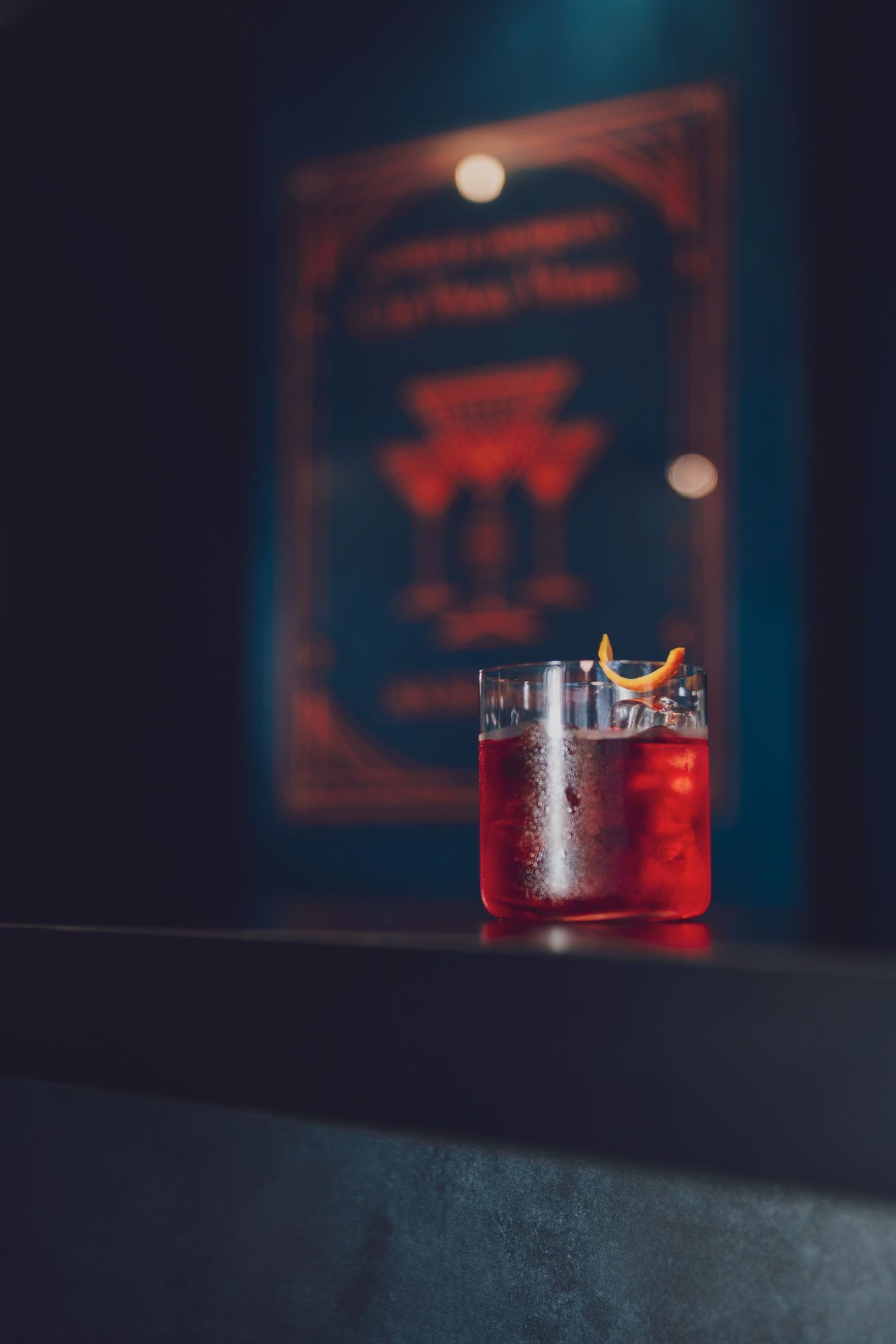 cocktail rosso in un bicchiere su un bancone scuro