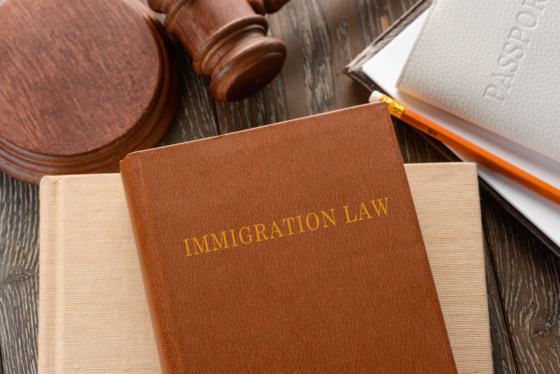 Immigration law book beside a gavel and open legal books on a desk