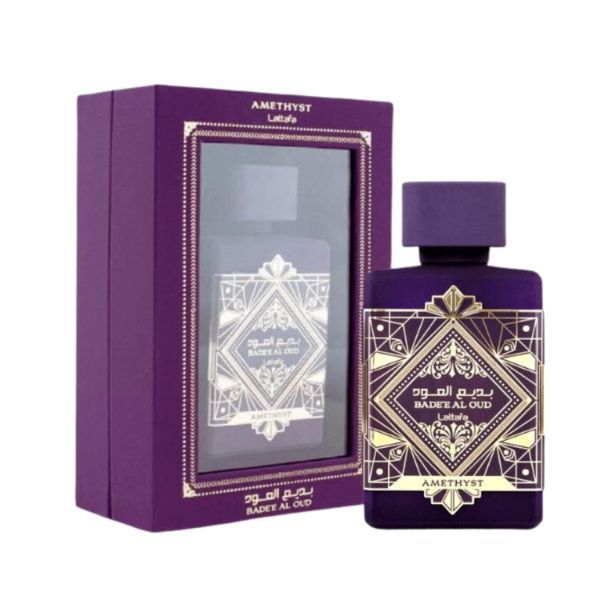 Frasco de perfume morado y caja a juego con etiqueta dorada ornamentada.