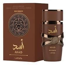 Frasco y caja de perfume Brown Asad Bourboon con letras árabes doradas y emblema circular.