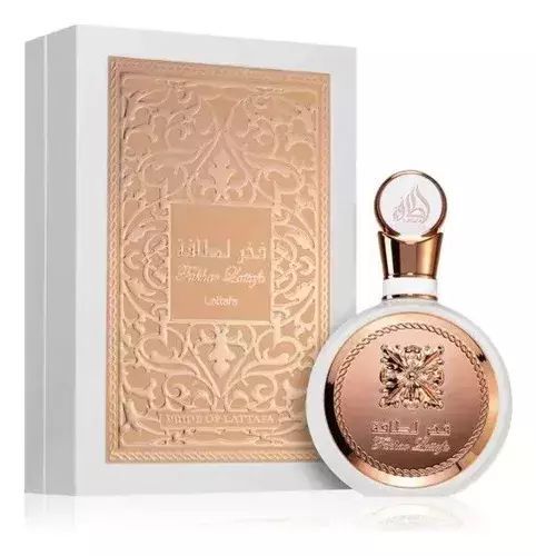 Frasco de perfume color oro rosa y caja ornamentada a juego sobre un fondo blanco.