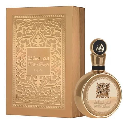 Frasco de perfume dorado con tapón ornamentado junto a una caja decorativa dorada a juego.