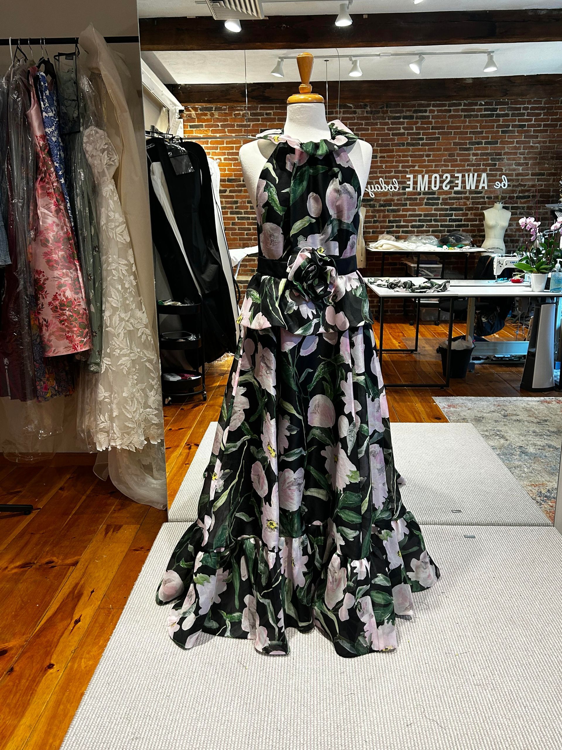Woman adjusting a sheer white veil on a dress form in a neutral room