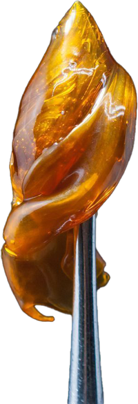 Amber-colored translucent carving on a metal stand, shaped like an abstract flame or leaf