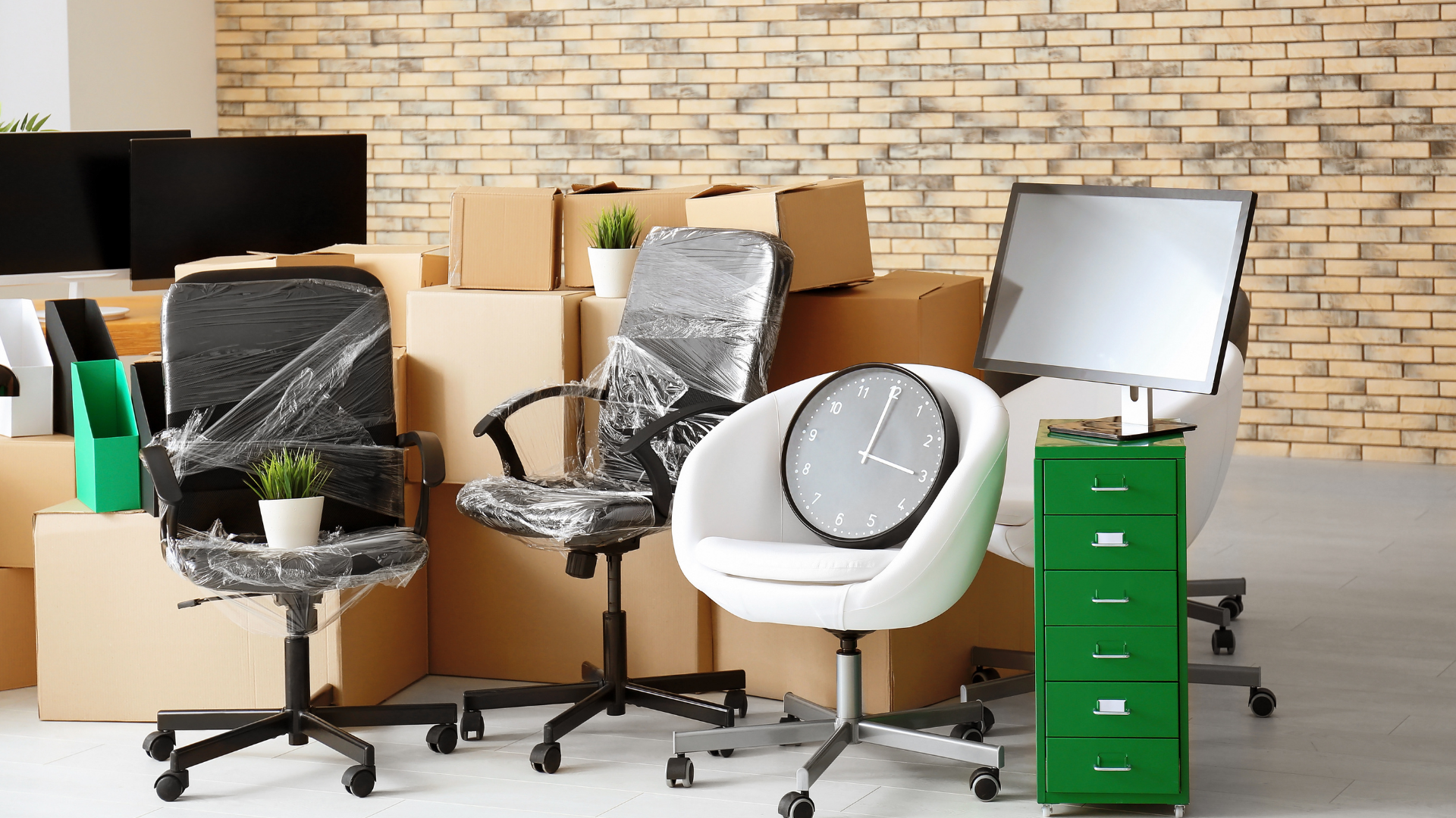 Office chairs, boxes, and a clock. Preparing to move in an office setting.