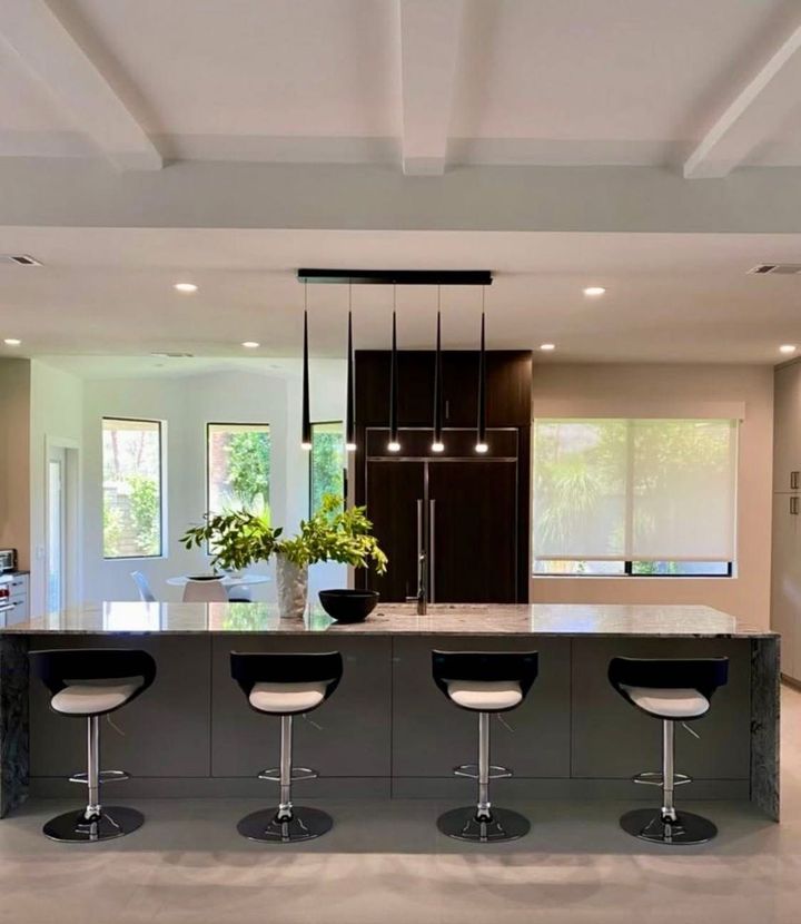White garage cabinets and countertop storage along a wall, with a blue water case on the shelf.