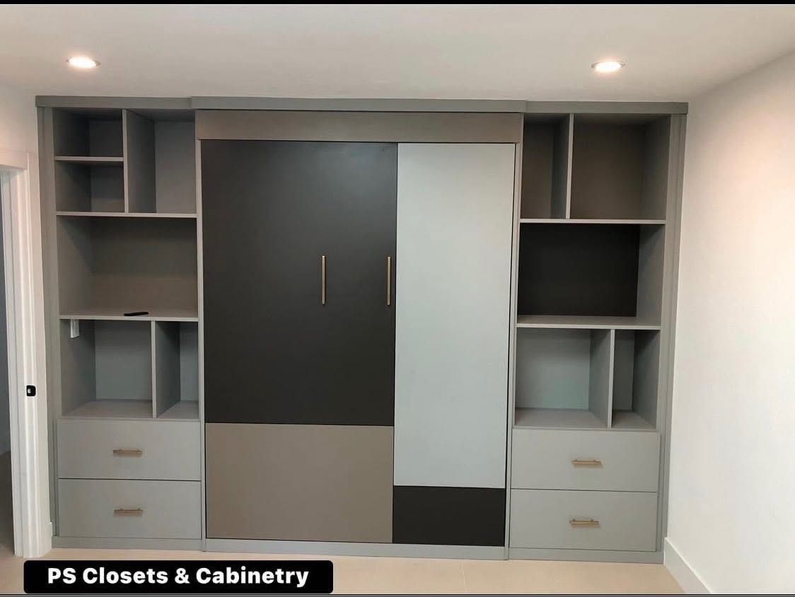 Built-in wardrobe with dark and light gray cabinets, drawers, and open shelving in a white room