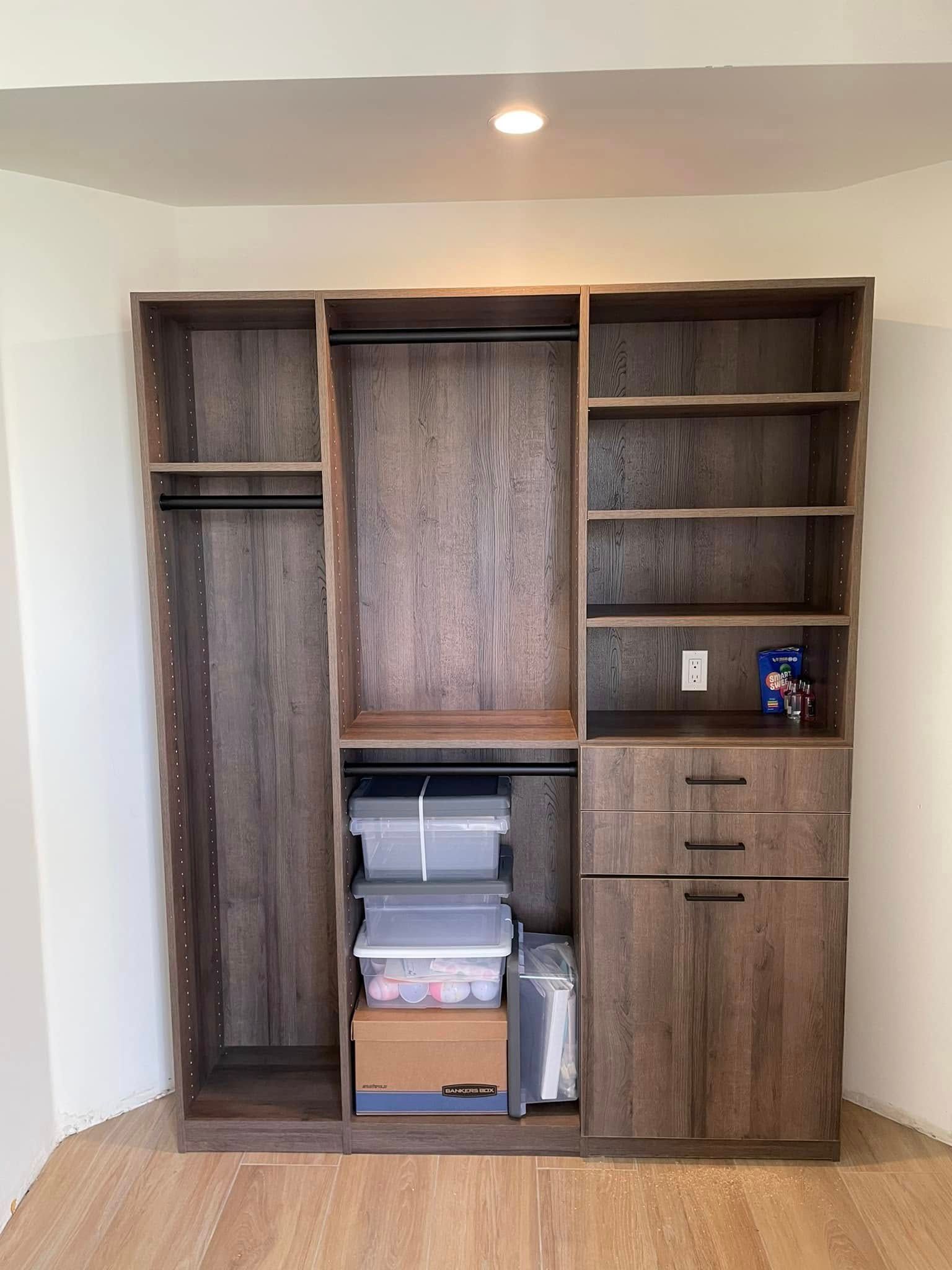 Built-in wooden wall unit with shelves, drawers, and storage bins in a room