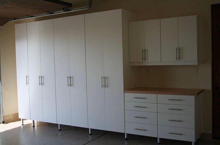 White storage cabinets and drawers against a beige wall in a room