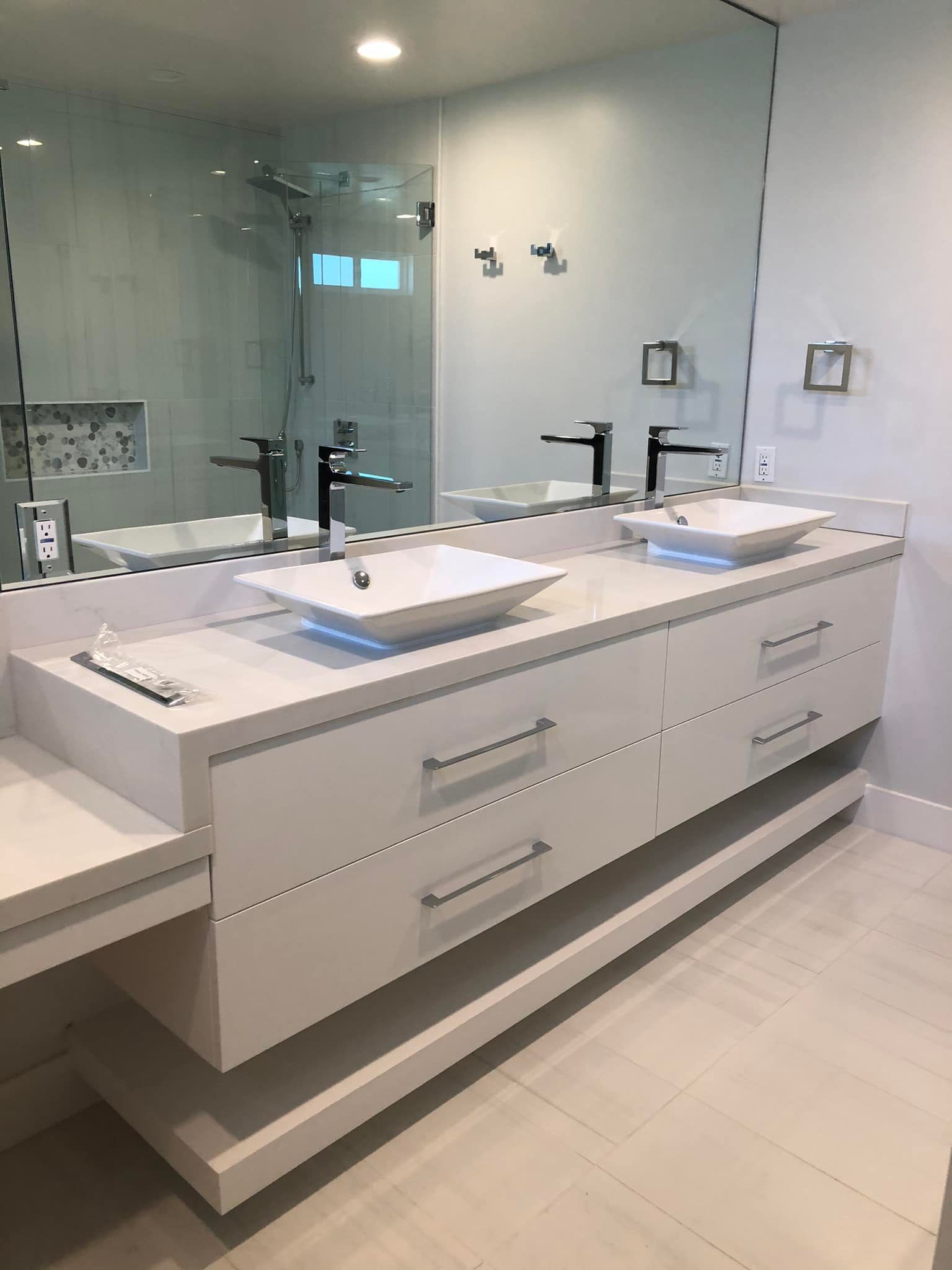 Modern white double vanity with sinks and mirrors in a bright bathroom