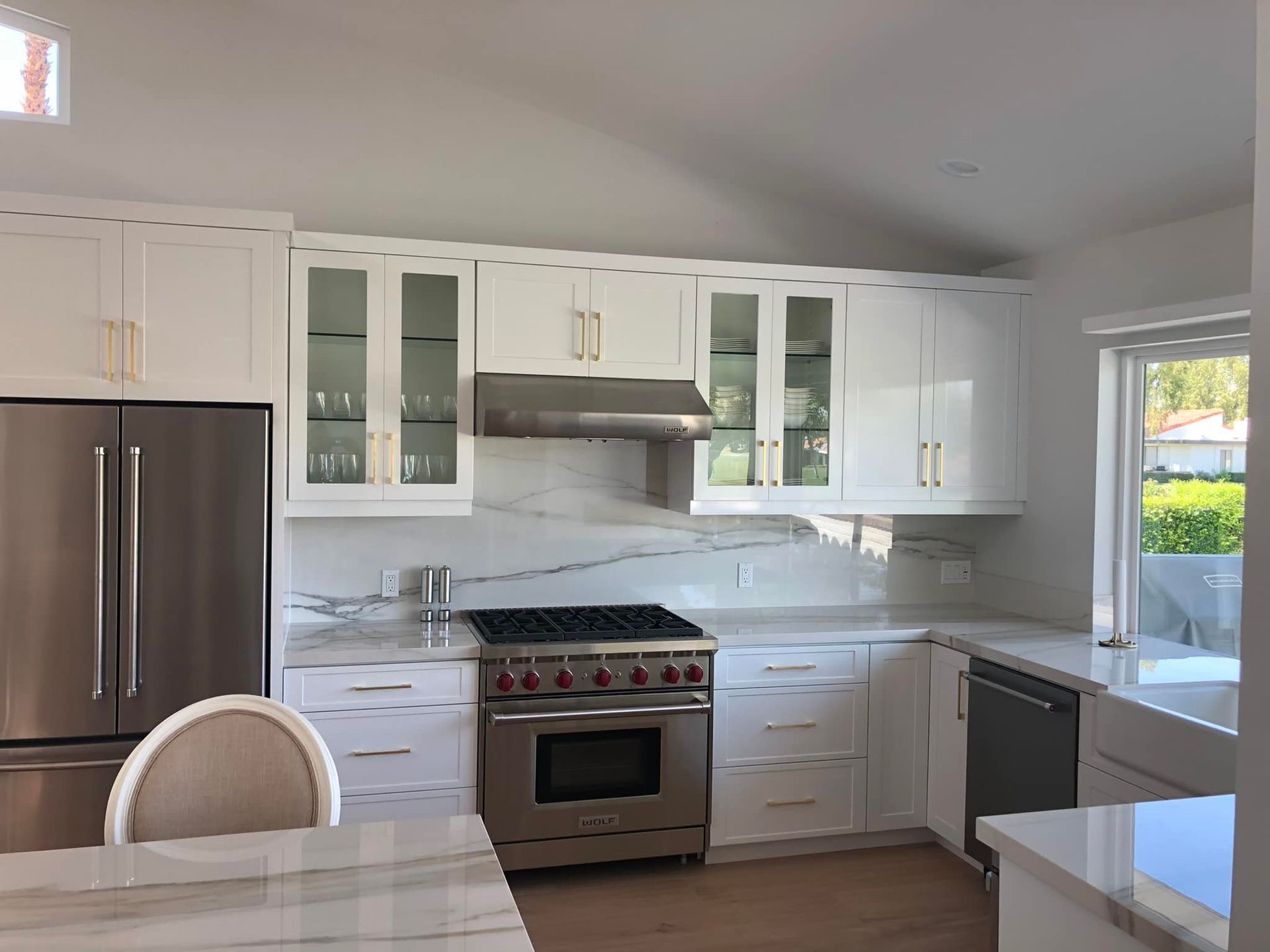Bright modern white kitchen with stainless steel appliances and marble countertops