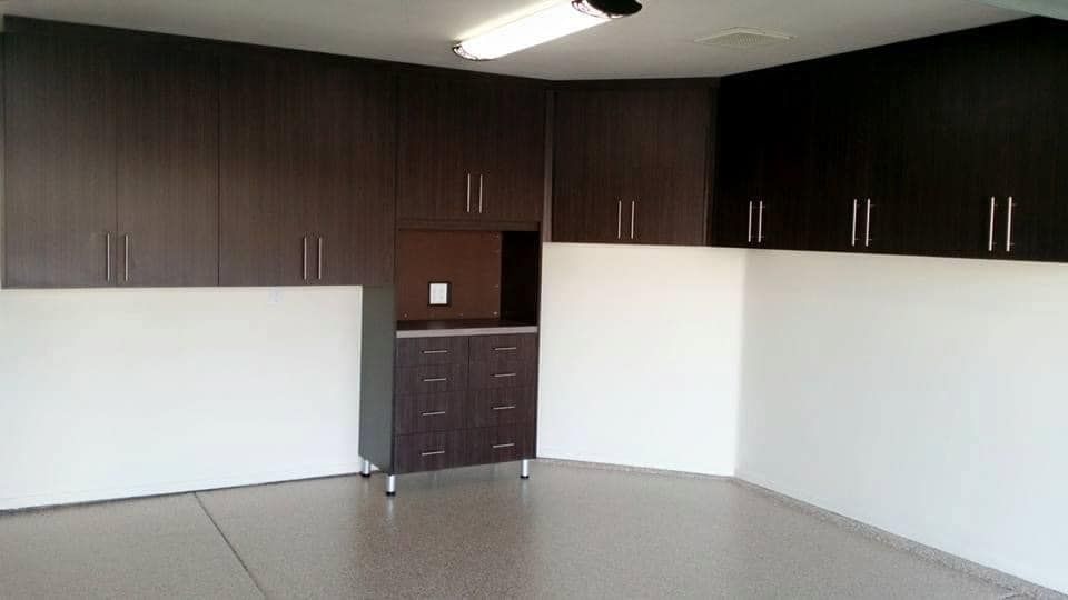 Empty room with dark wood cabinets, white walls, and a light tiled floor