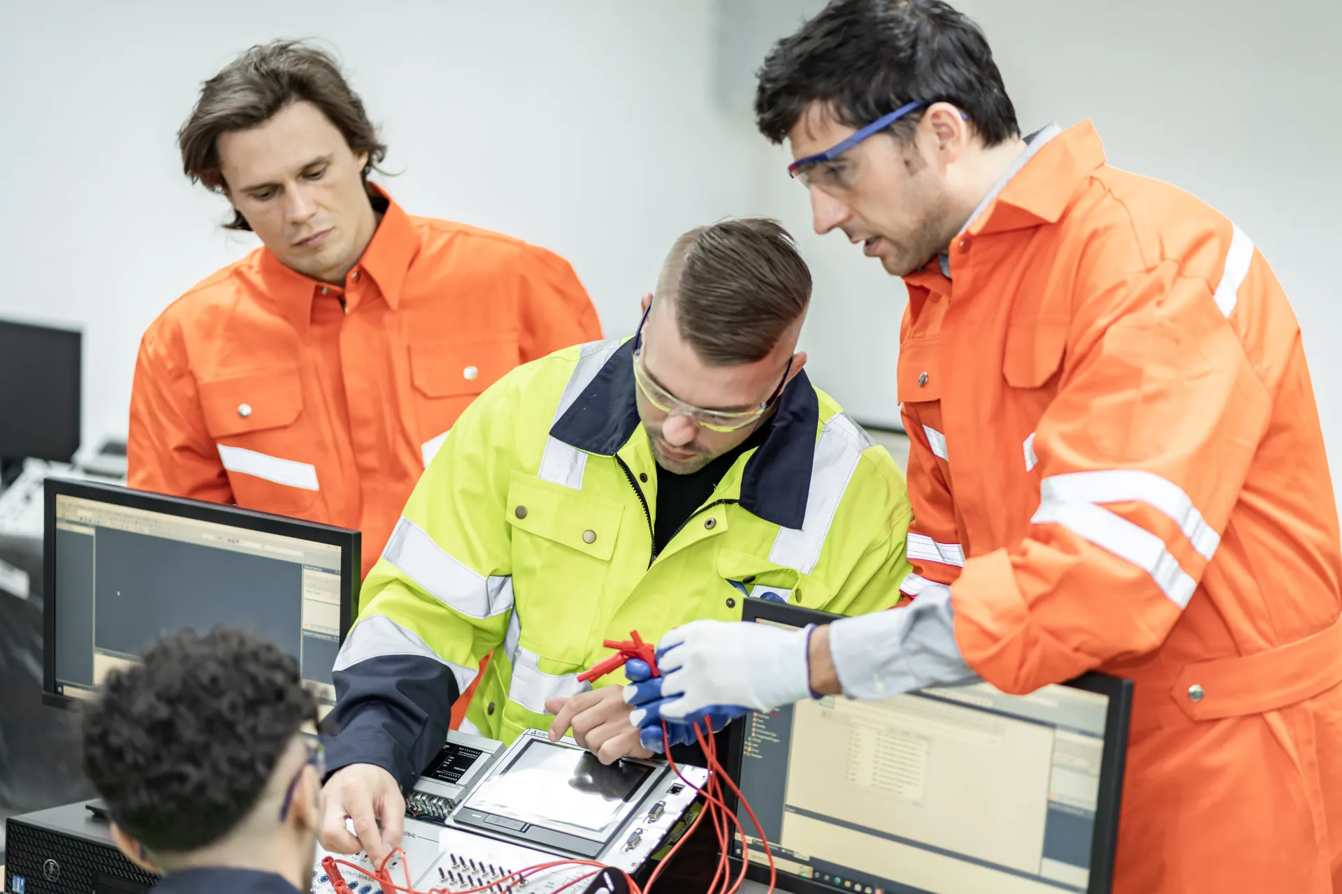 A group of men are working on a computer in a room.