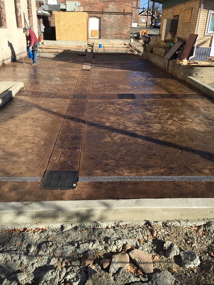 Rusty metal platform in an industrial yard, with a concrete edge and rubble in the foreground.